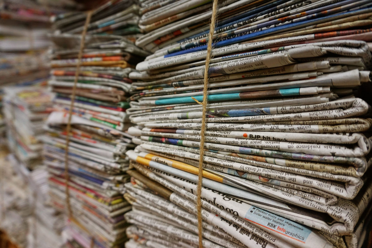 newspapers stacked and tied with string